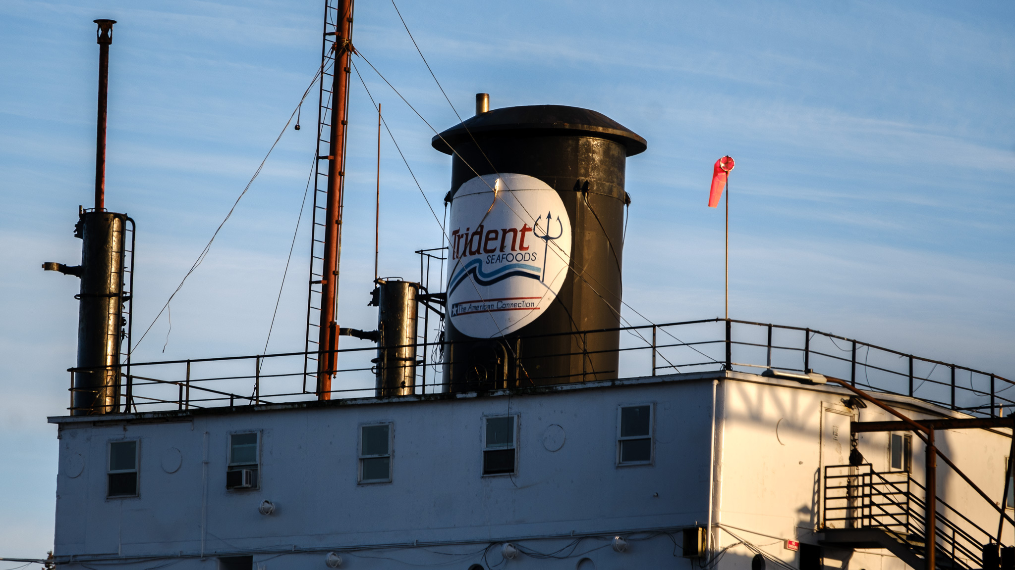 a square building with a large black cylinder, possibly for exhaust, that reads "Trident Seafoods"