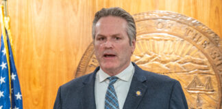 Man speaking in front of state seal