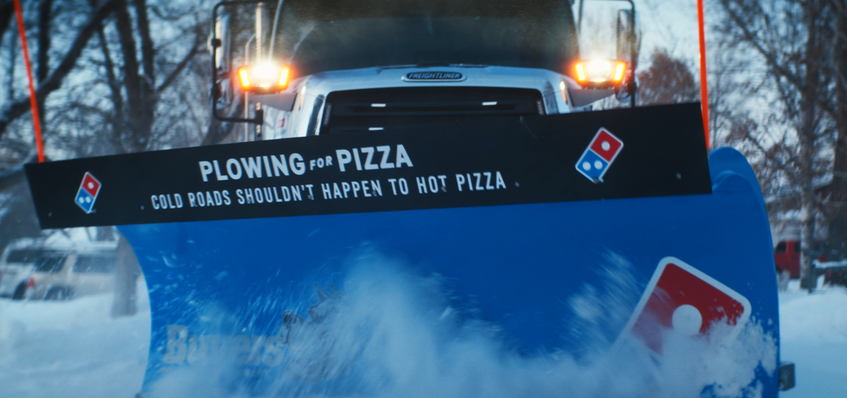 A "Plowing for Pizza" branded snow plow truck
