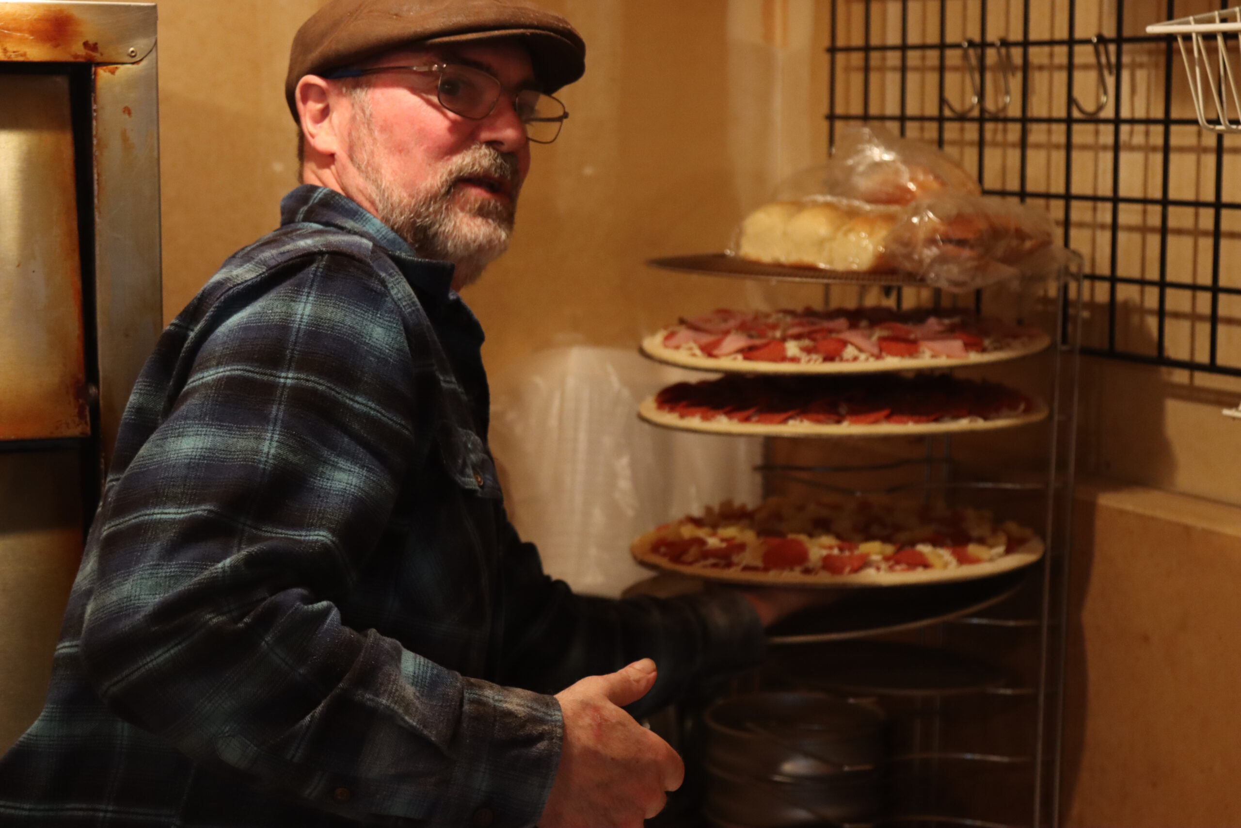 a man puts pizzas on a rack
