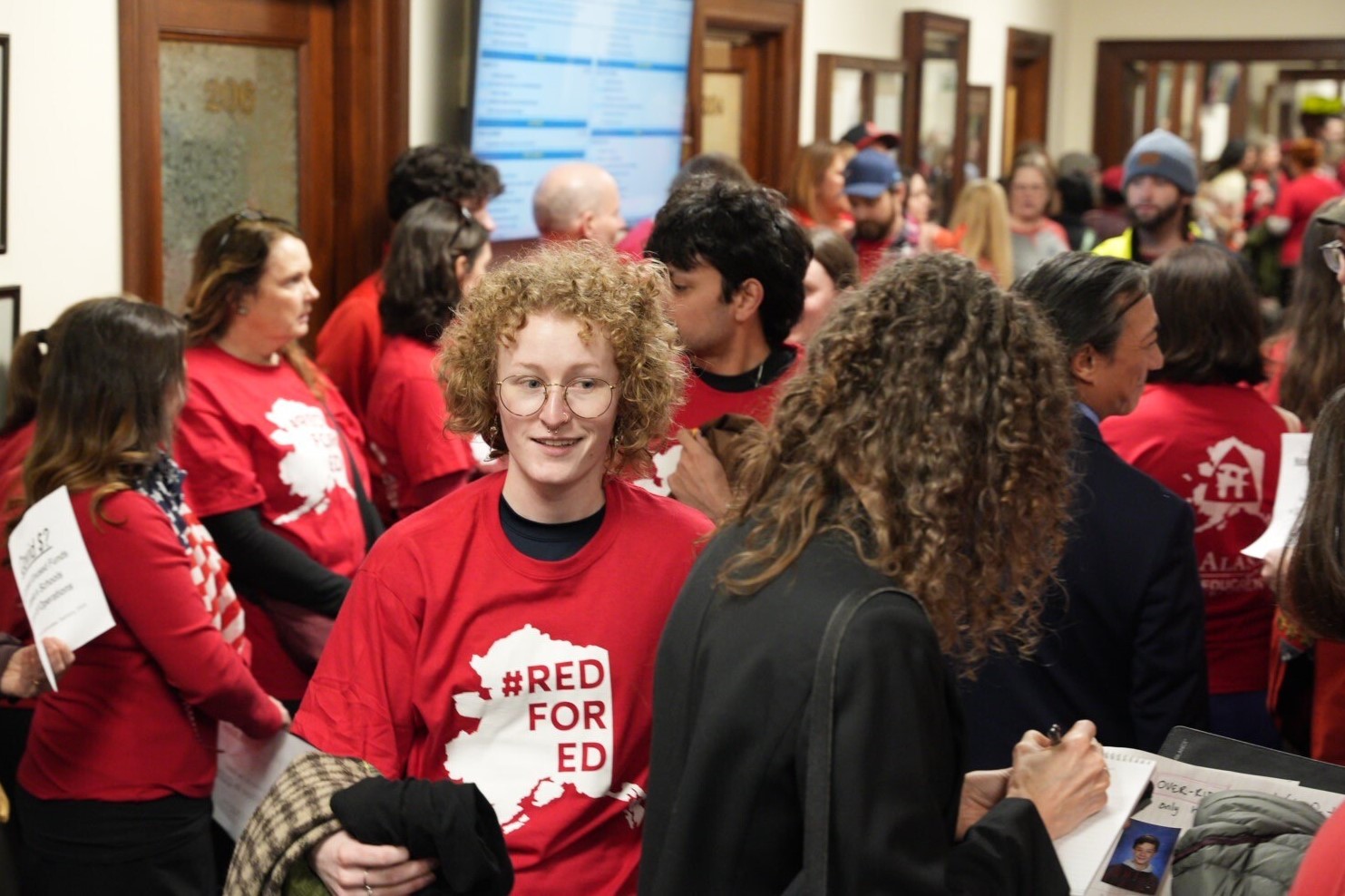 people in red t shirts crowd a hallway