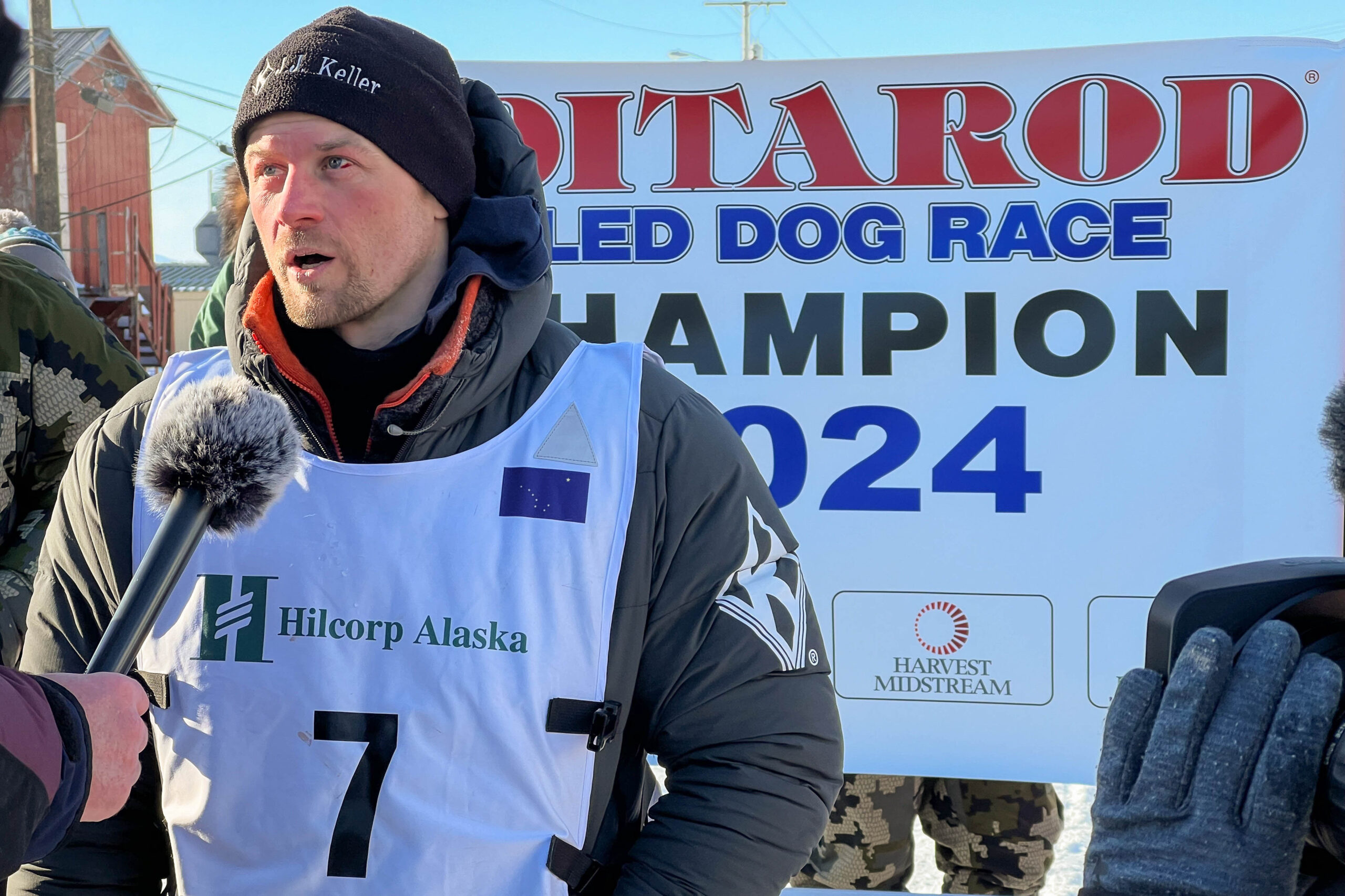a musher speaks into a microphone
