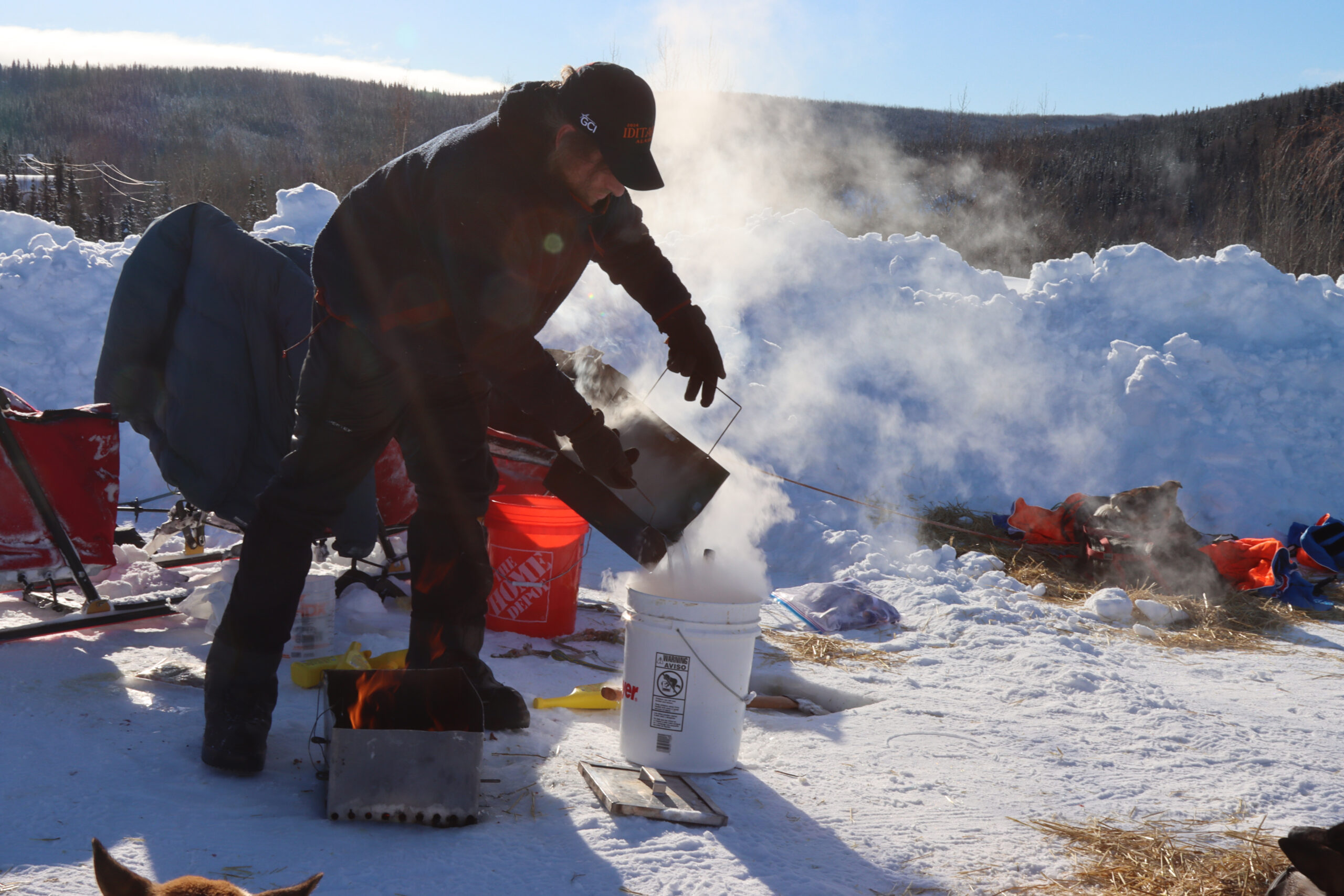 a musher mixes food and hot water, creating steam outside