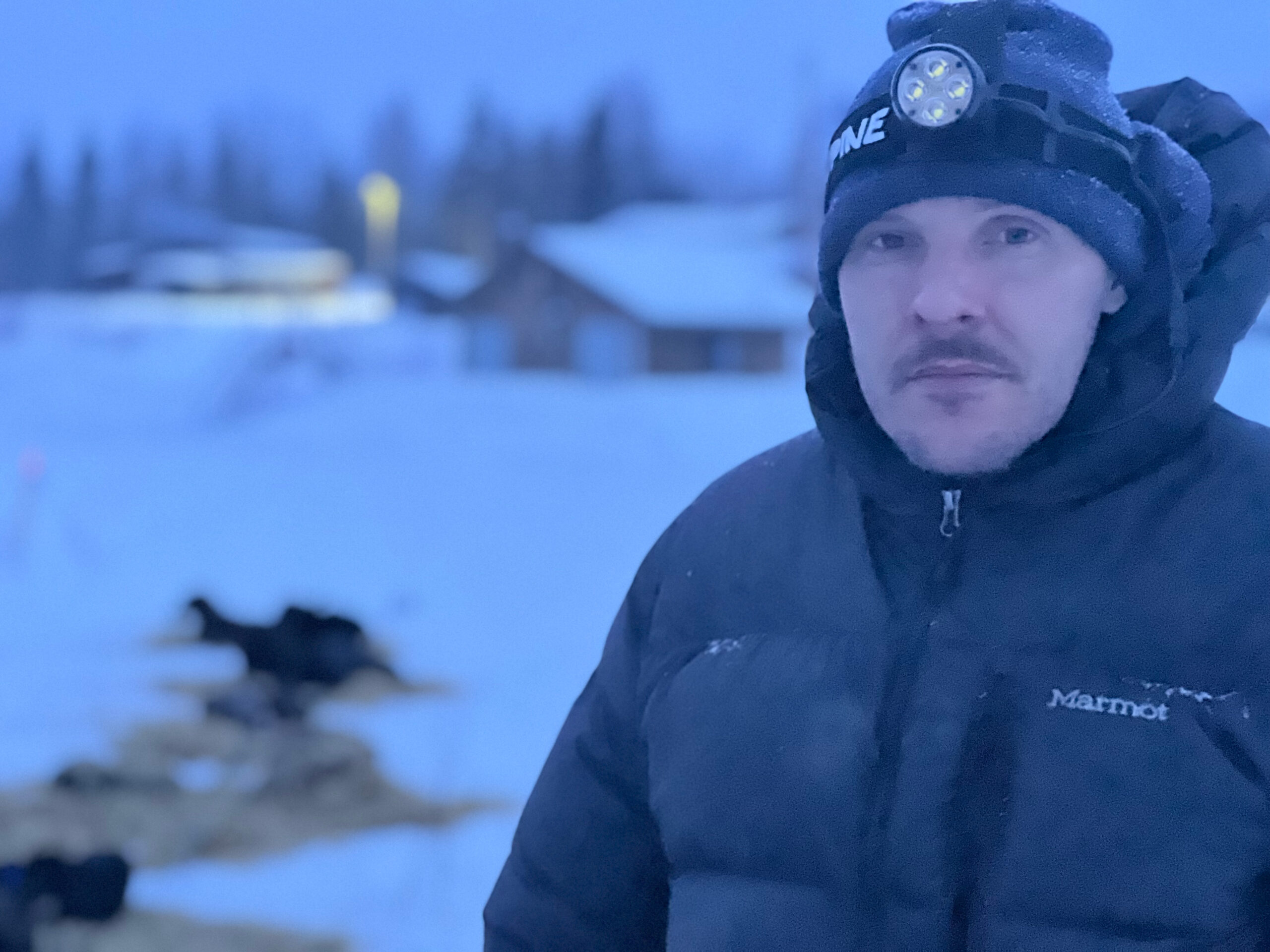 a musher with a headlamp outside