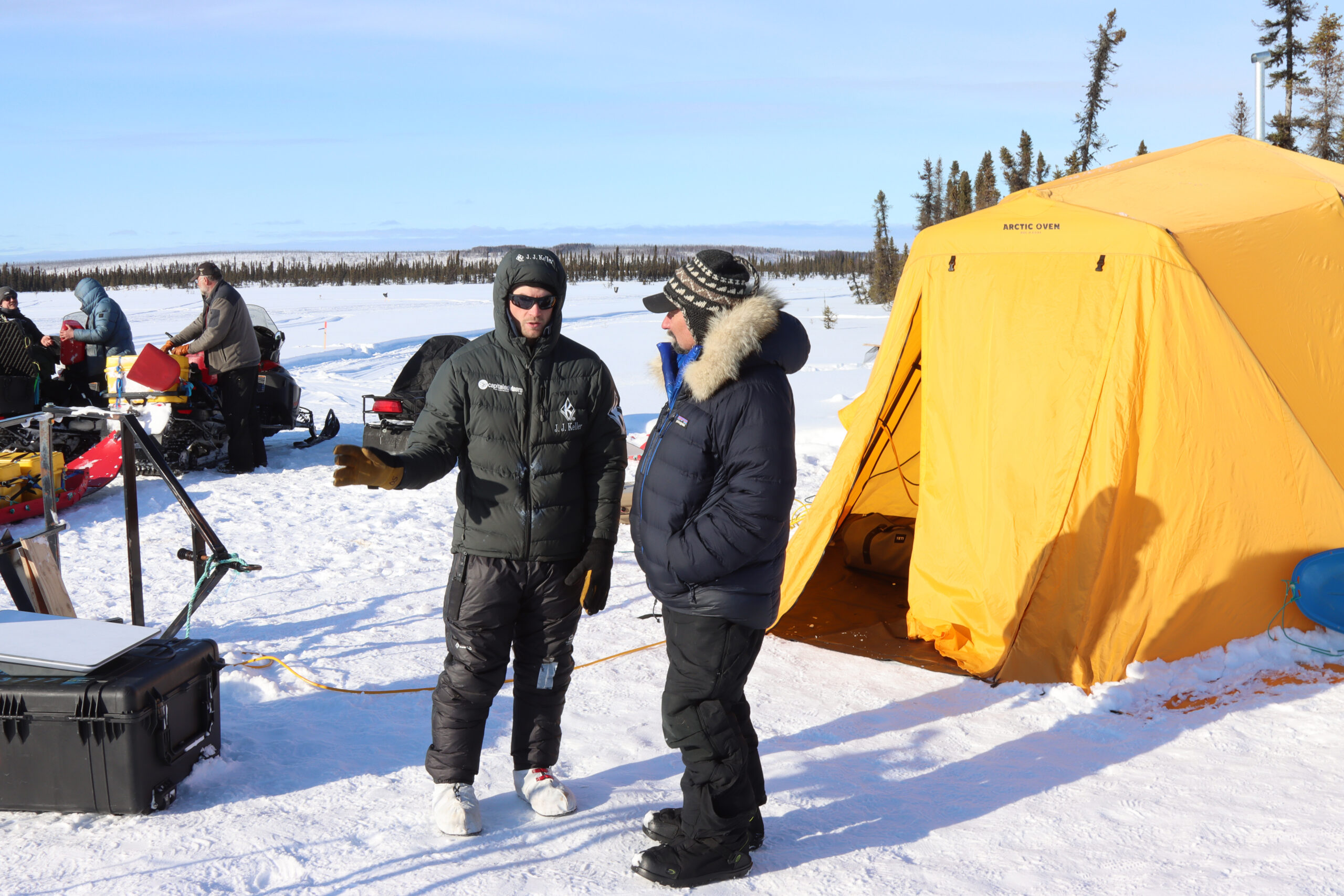 a musher talks to another man outside