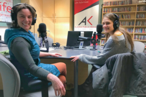 Two women sit in a radio studio.
