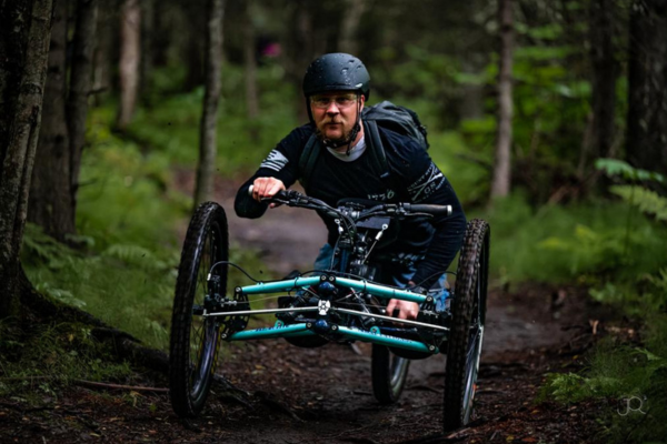 A man rides an adaptive mountain bike.