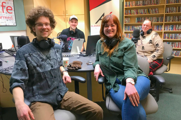 Two men and two women sit in a radio studio. 