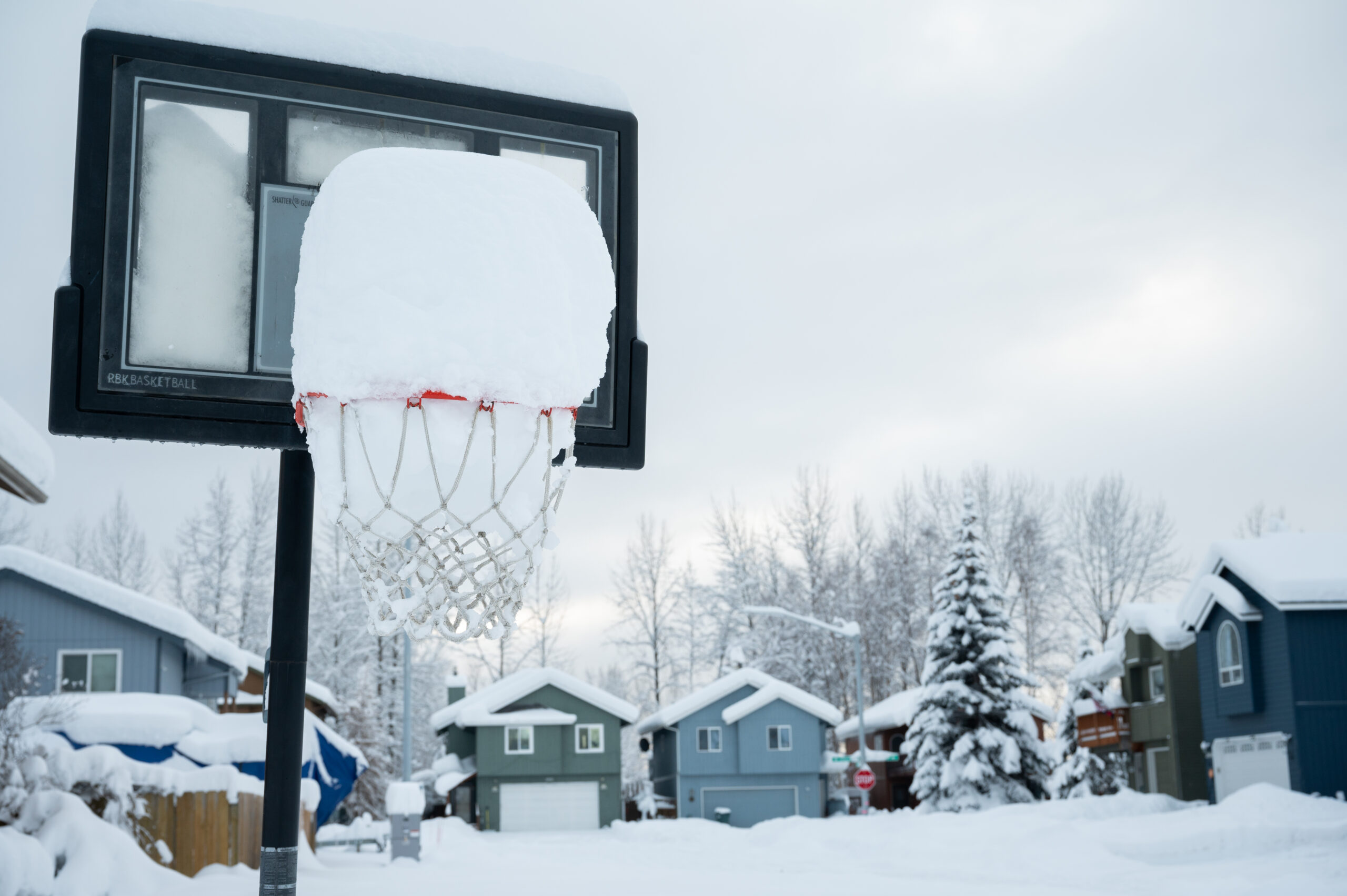 A basketball hoop full of snow