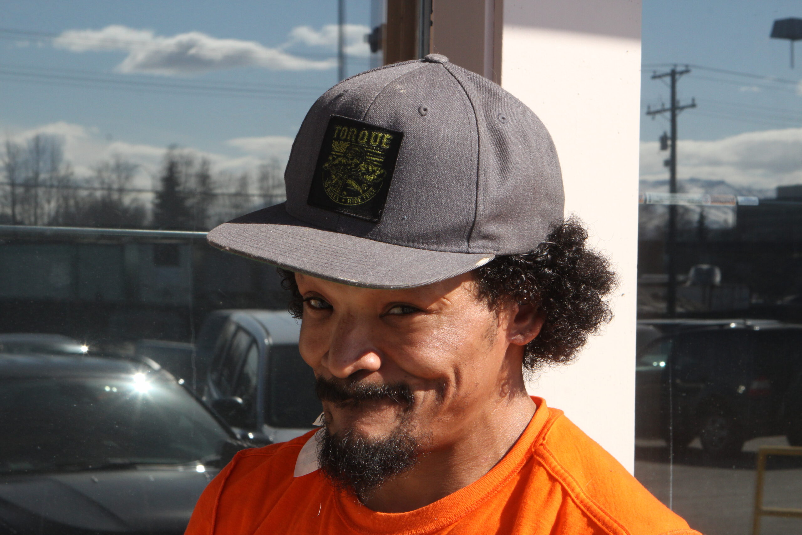 a man in a baseball cap smirks