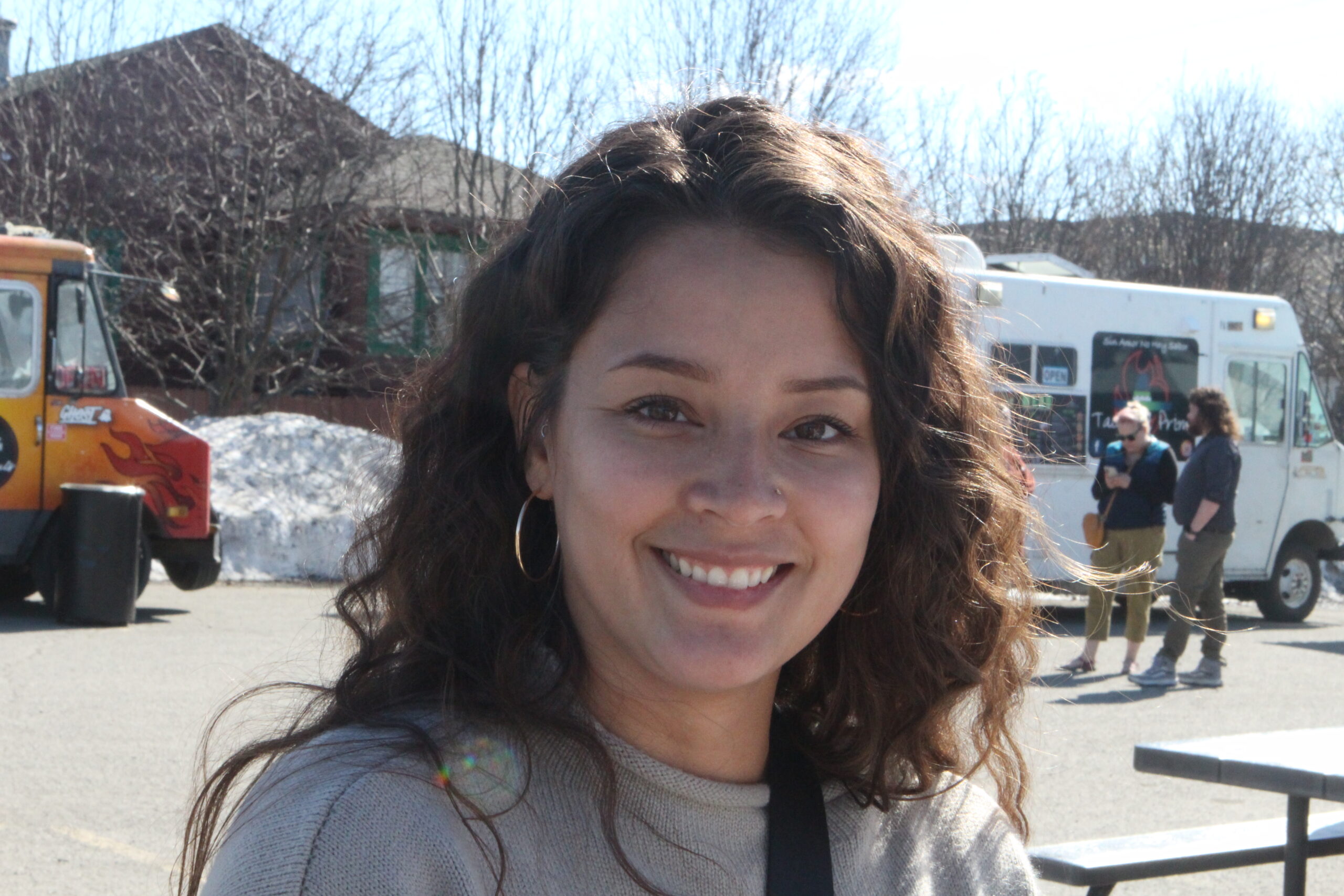 a woman smiles near food trucks