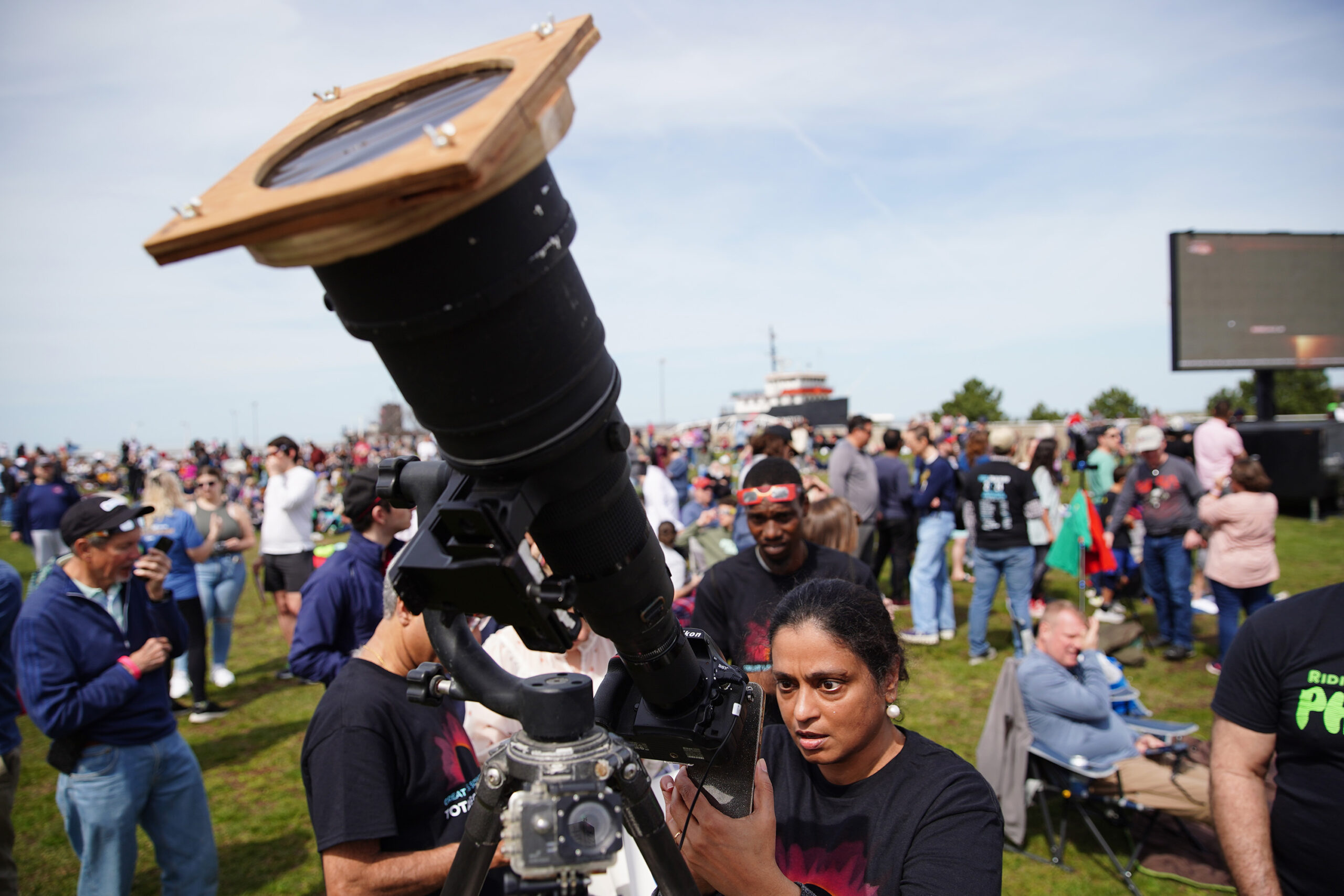 a person uses a long lens to try to photograph the eclipse