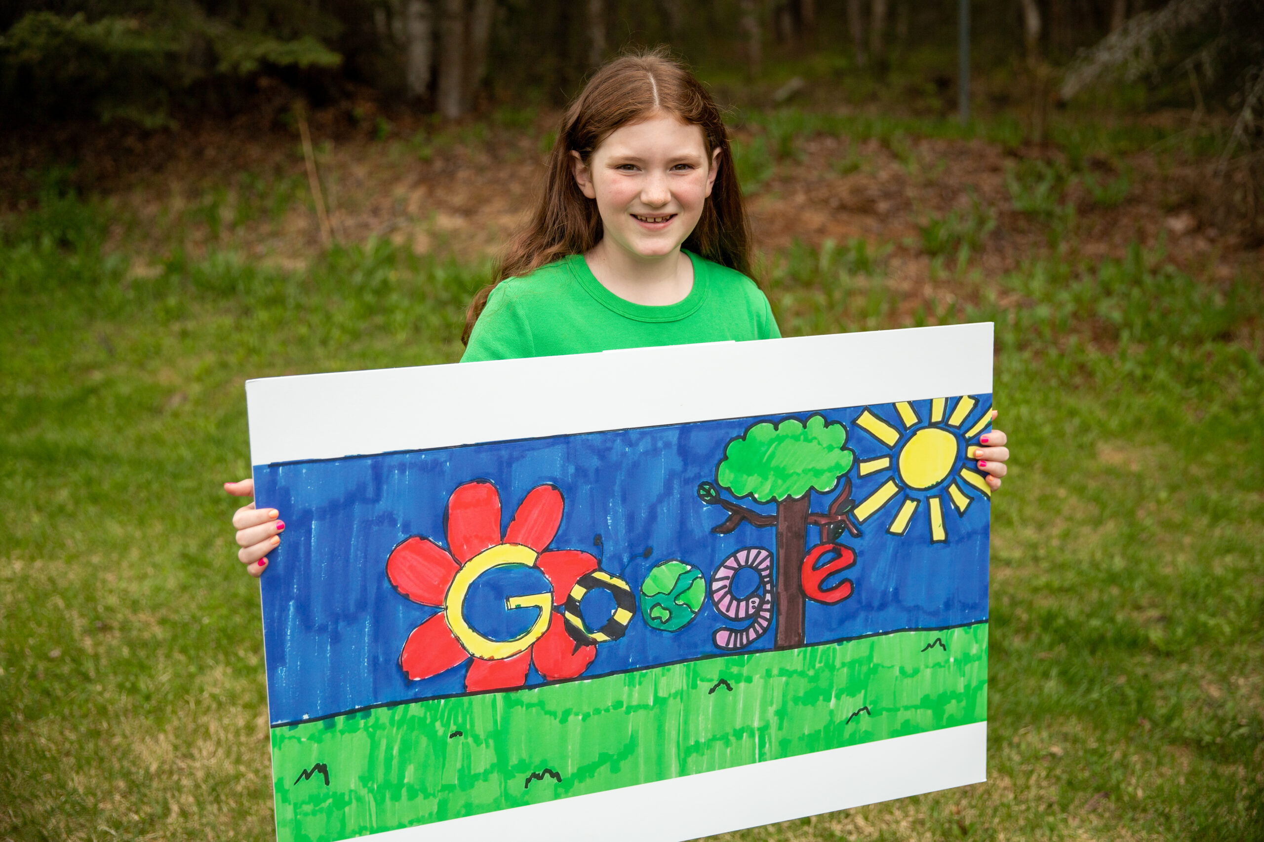 A third-grade student holds her Doodle for Google artwork.