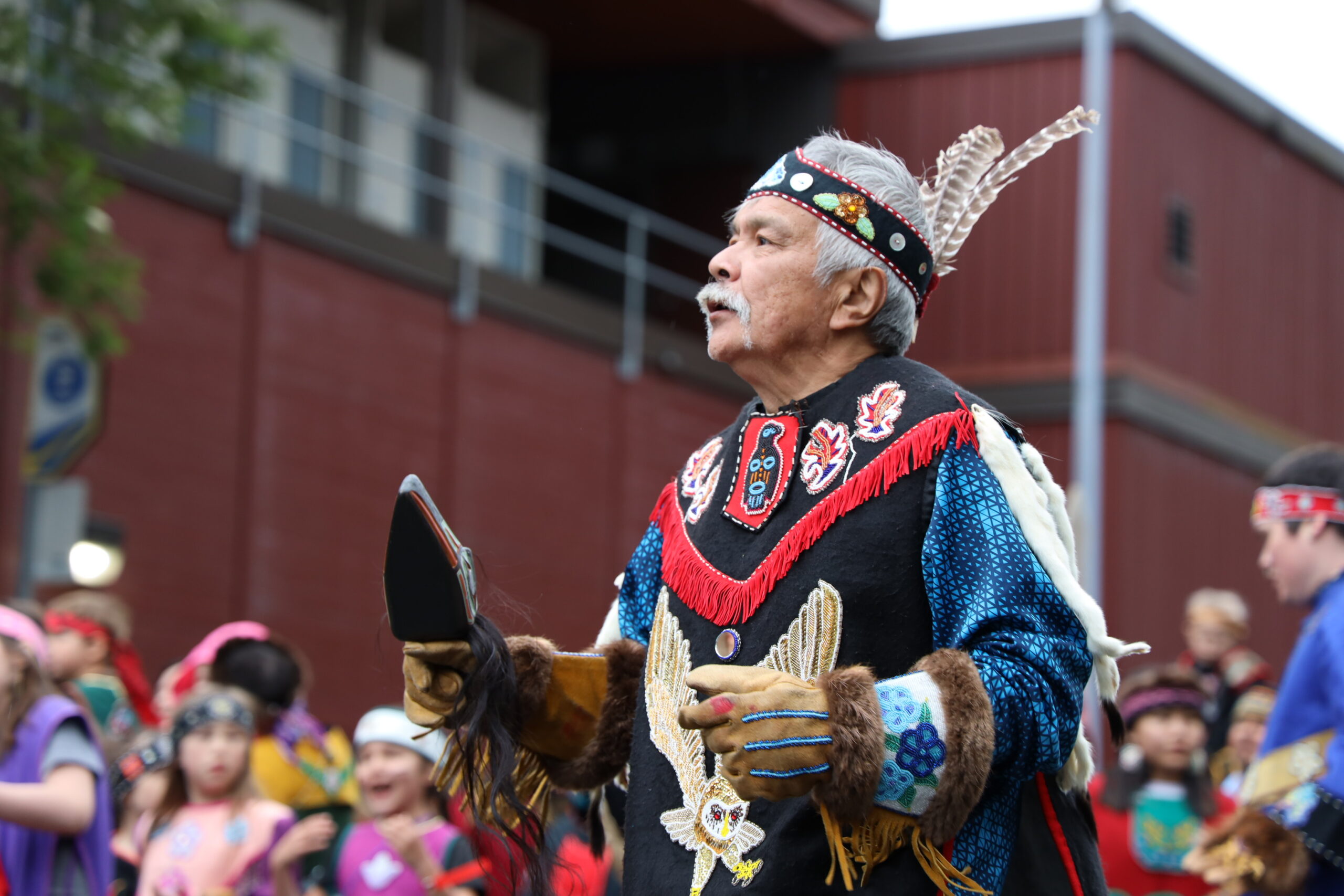 a man dances in the streets in traditional clothing for a celebration