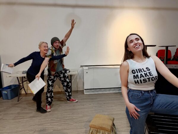 Three people rehearse for a play. 