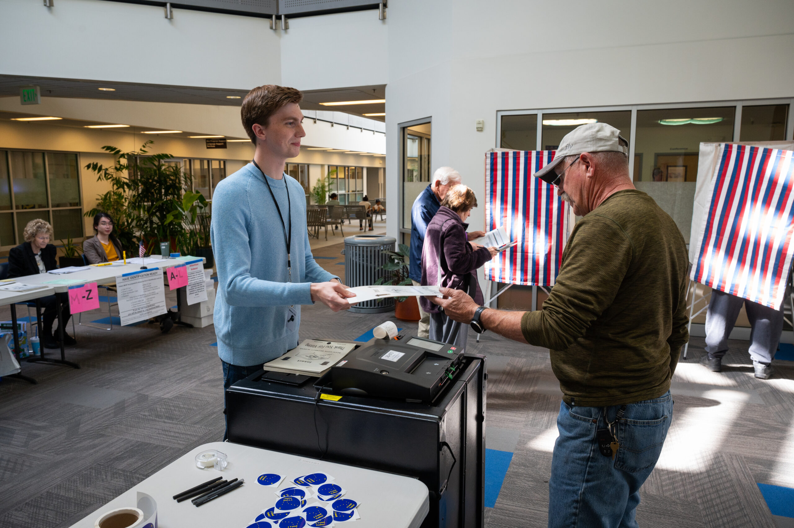 A man successful a bluish garment takes a ballot from a voter.