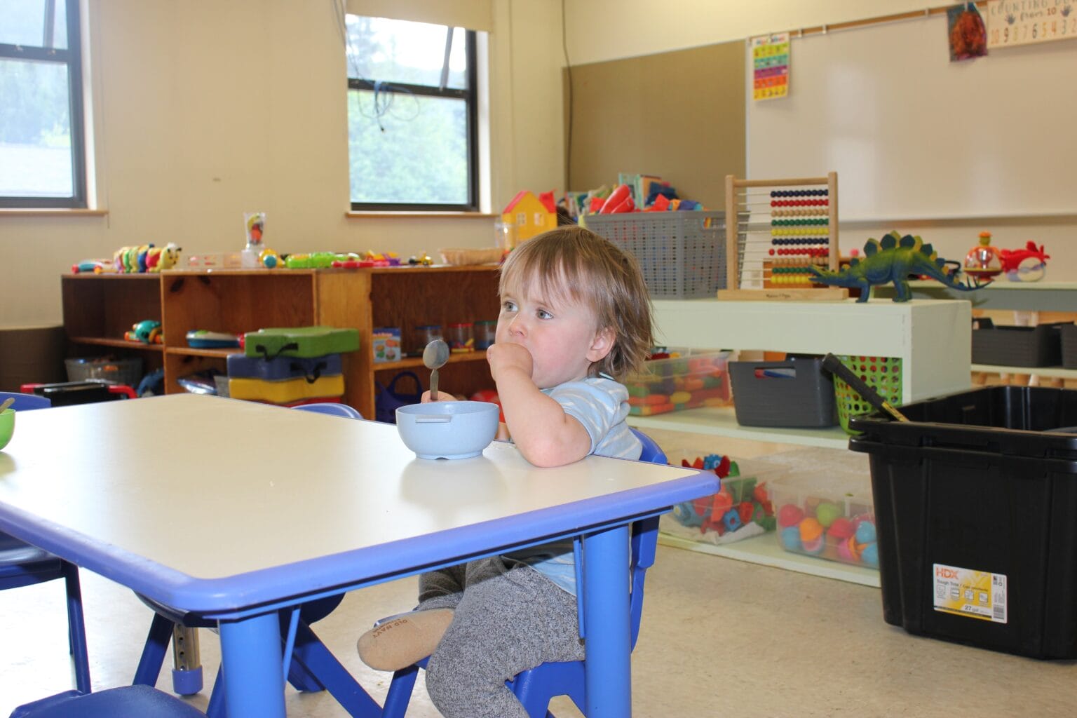 a kid eating astatine at a table