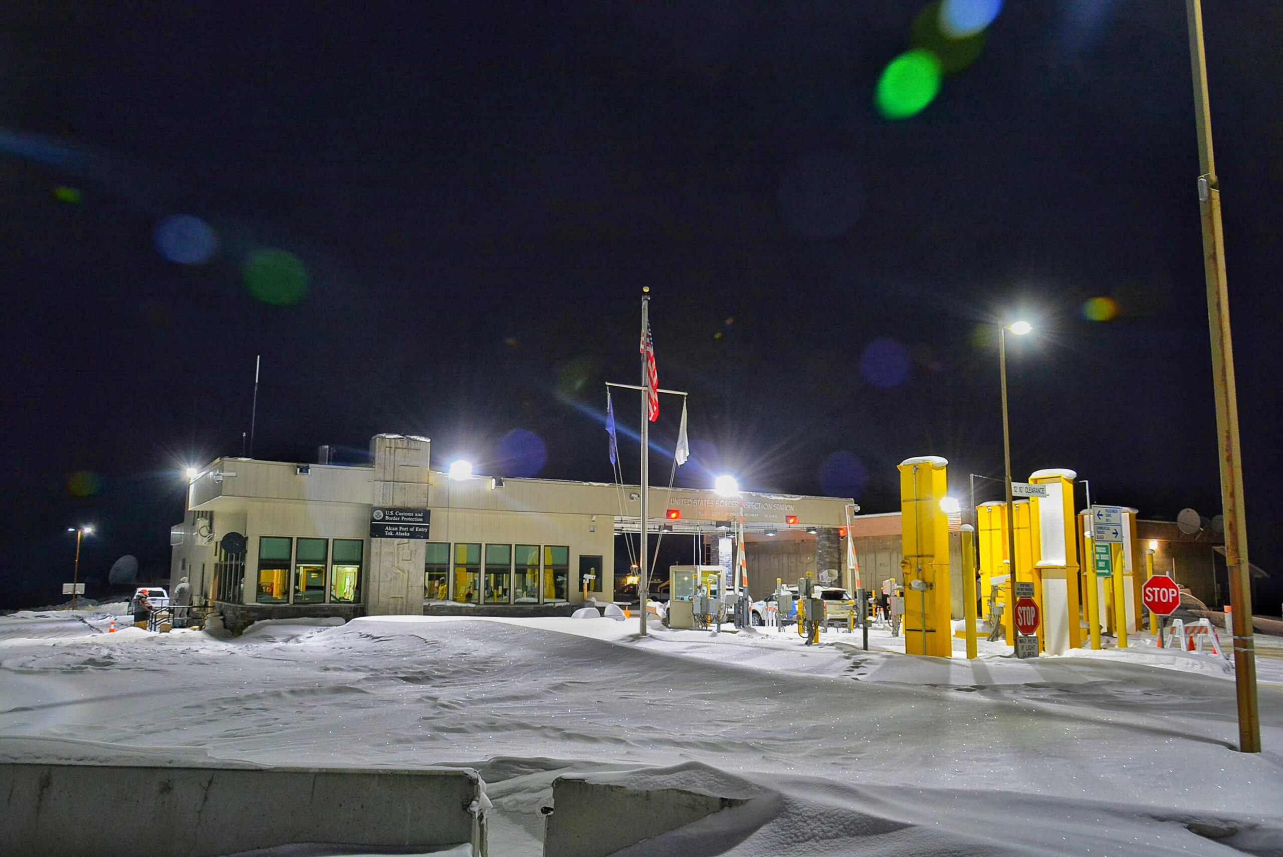 a photograph of nan separator crossing building astatine night, pinch much of nan crushed covered successful snow. nan entity is achromatic and 2 streetlights illuminate nan photo