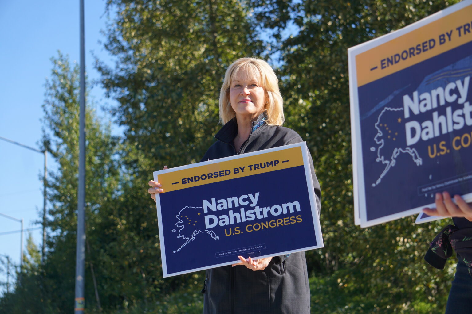 a female holding a motion that says "Nancy Dahlstrom U.S. Congress"