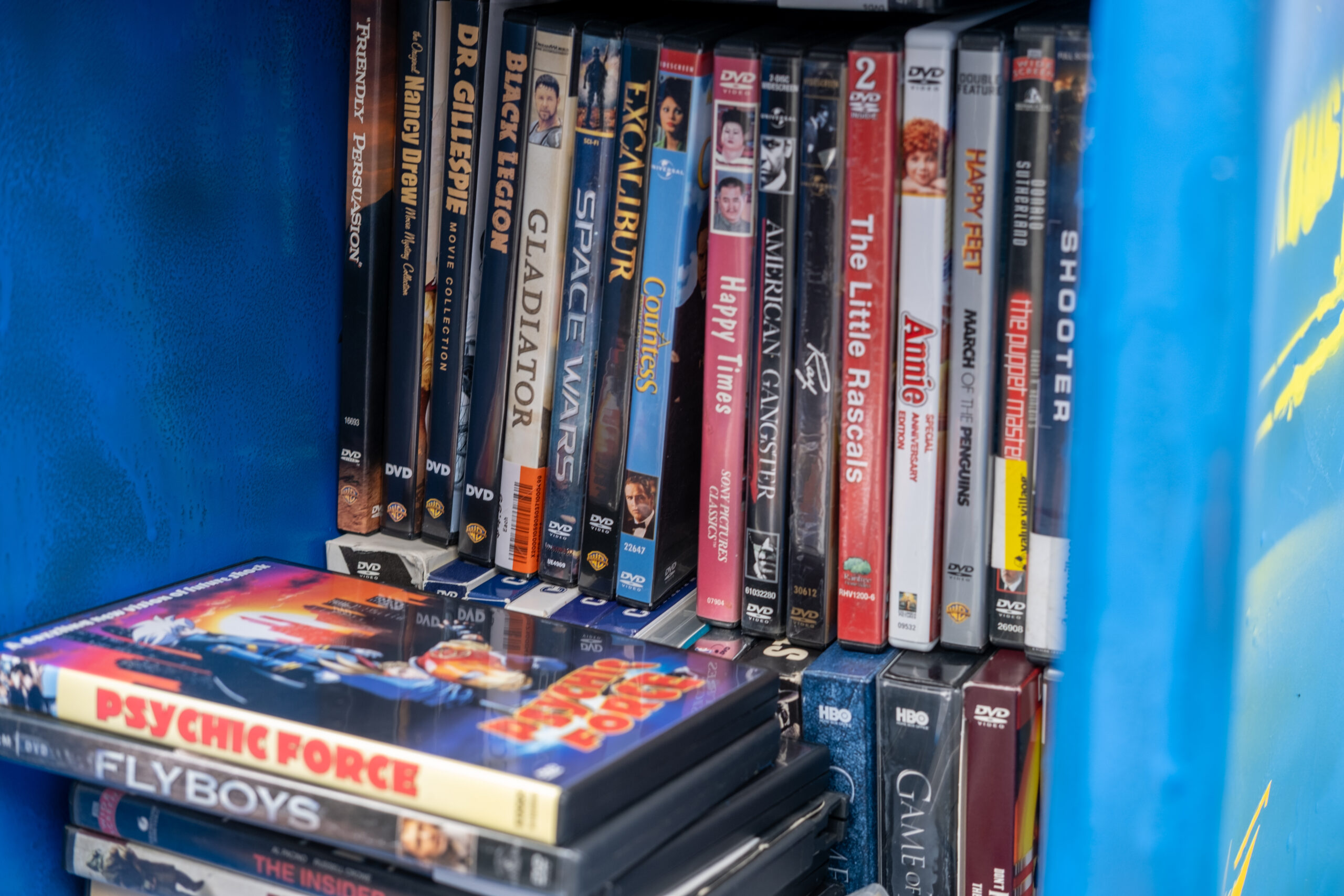 a close up on a small shelf filled with DVD cases 