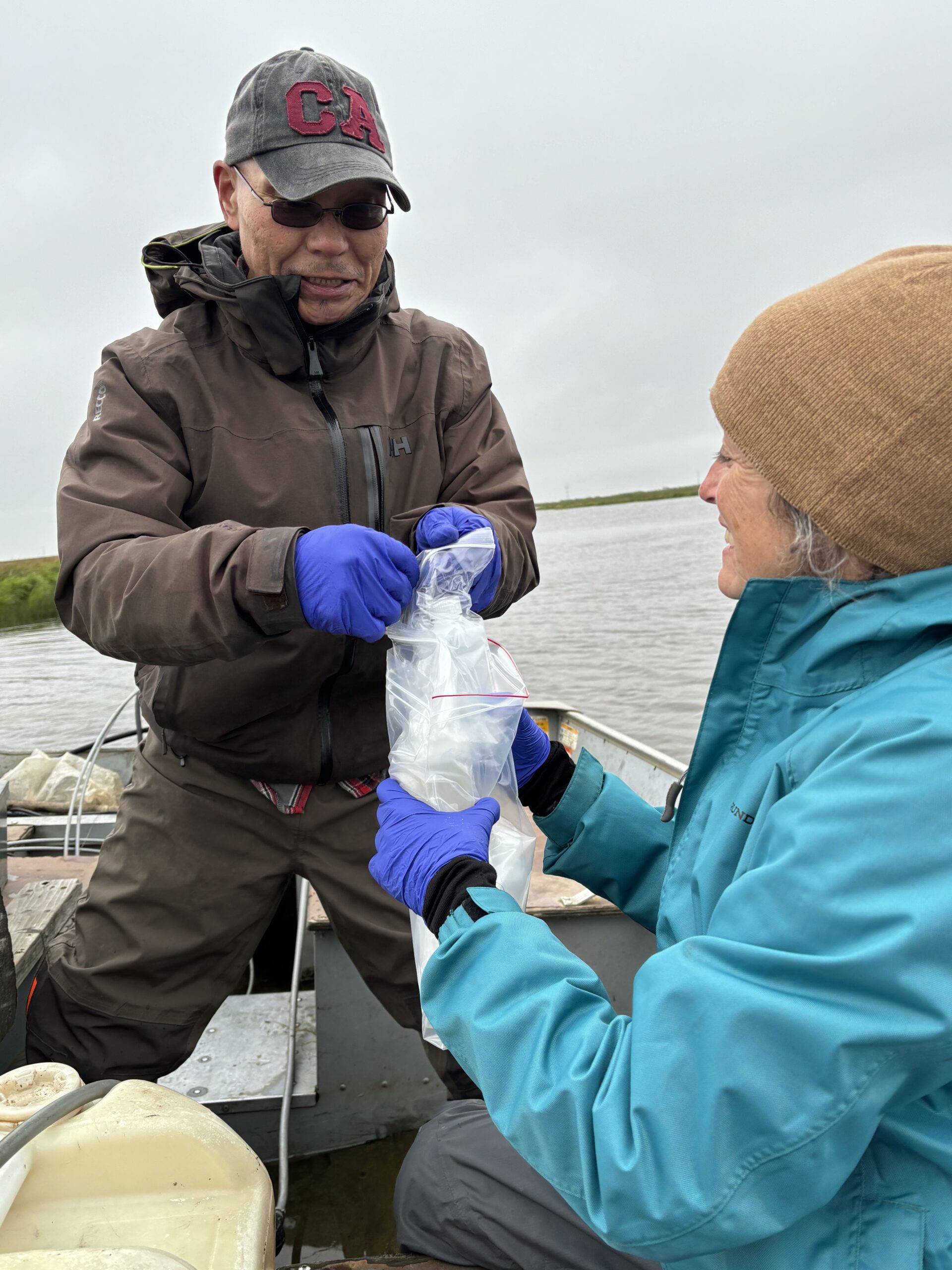 a man successful a vessel holds respective ziplock bags, a female besides successful nan vessel is helping him untangle nan ziplock bags