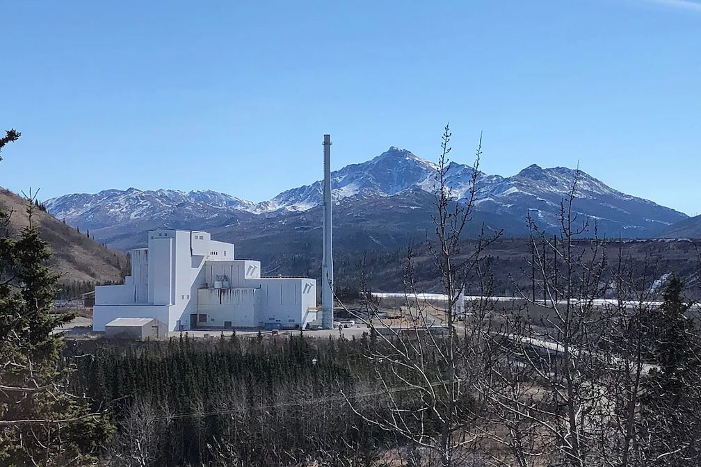 a coal-fired plant with mountains in the background