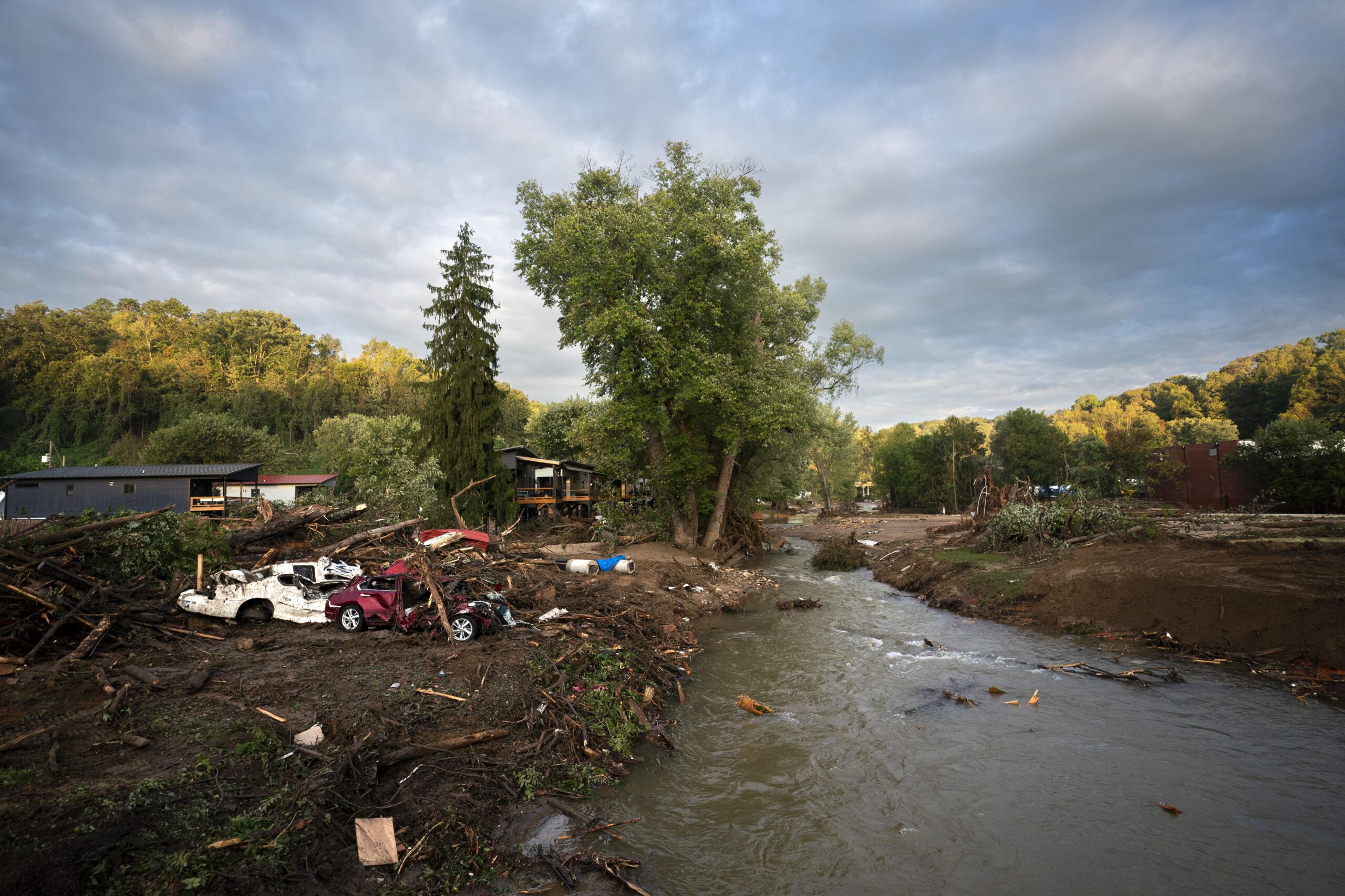 crushed cars and debris as water floods the area