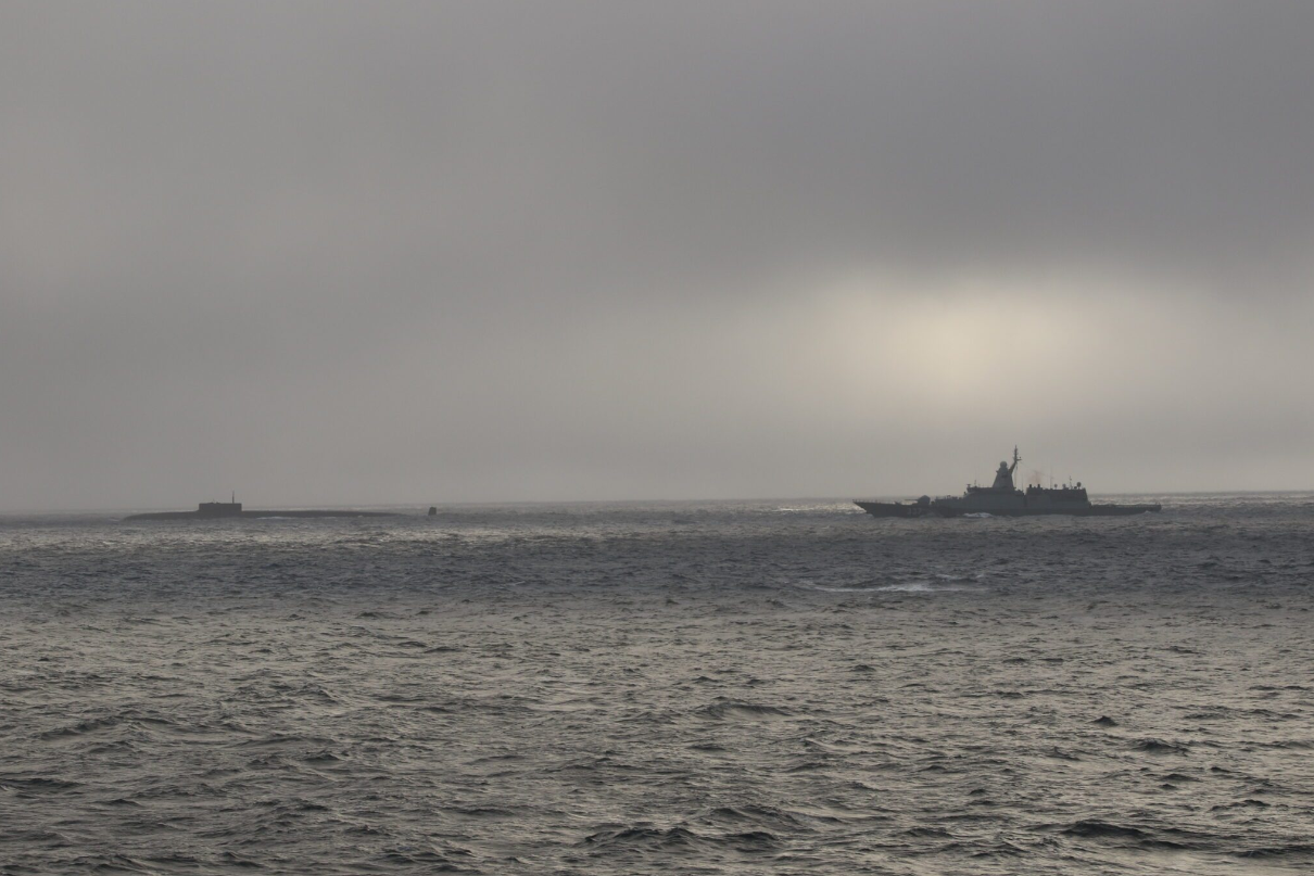 A United States ship and Russian ship in the ocean.