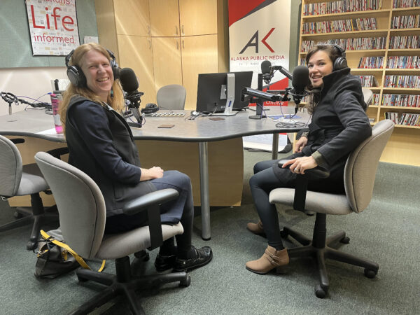 Two women sit in a radio studio. 