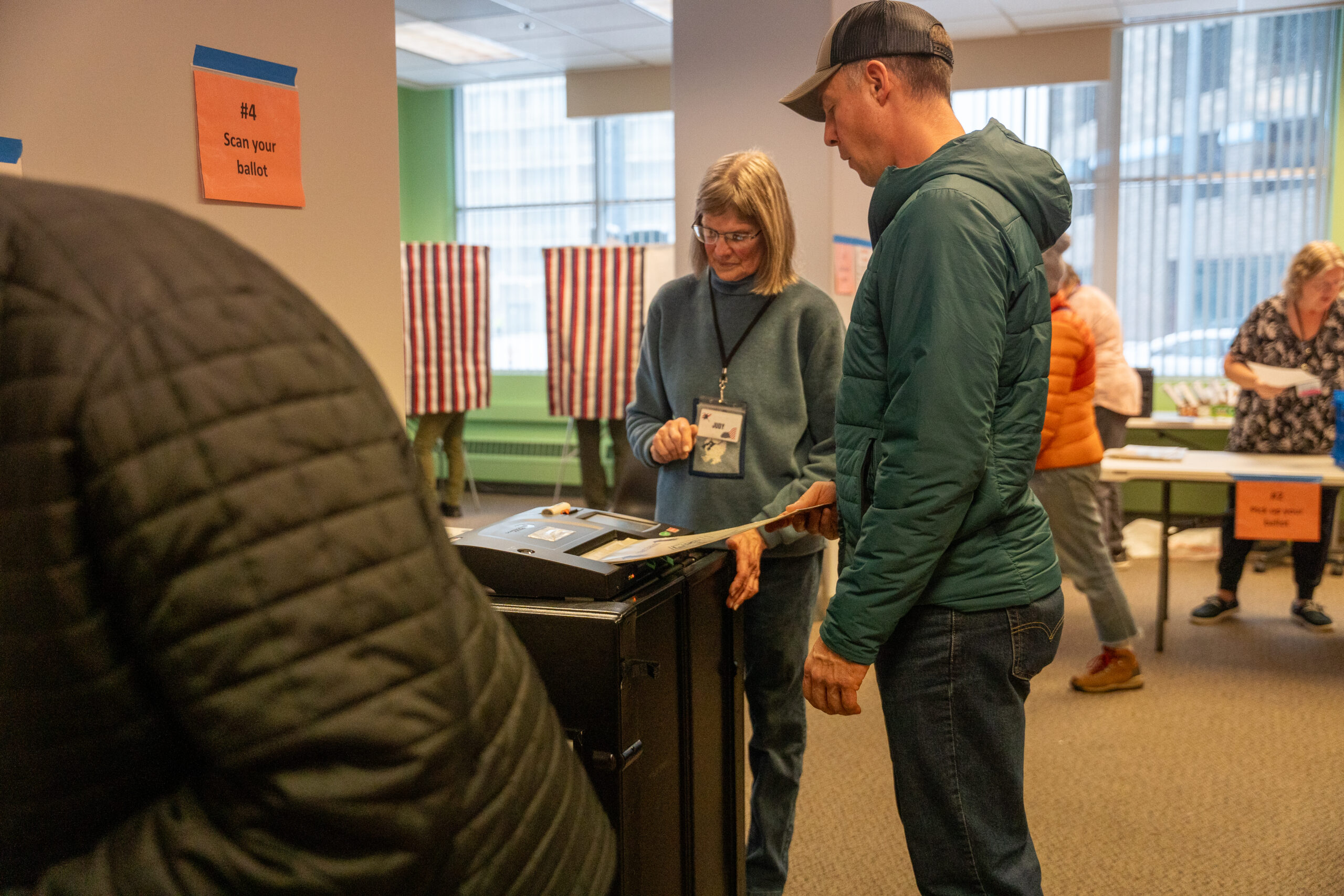 A person placing their ballot inside a scanner.