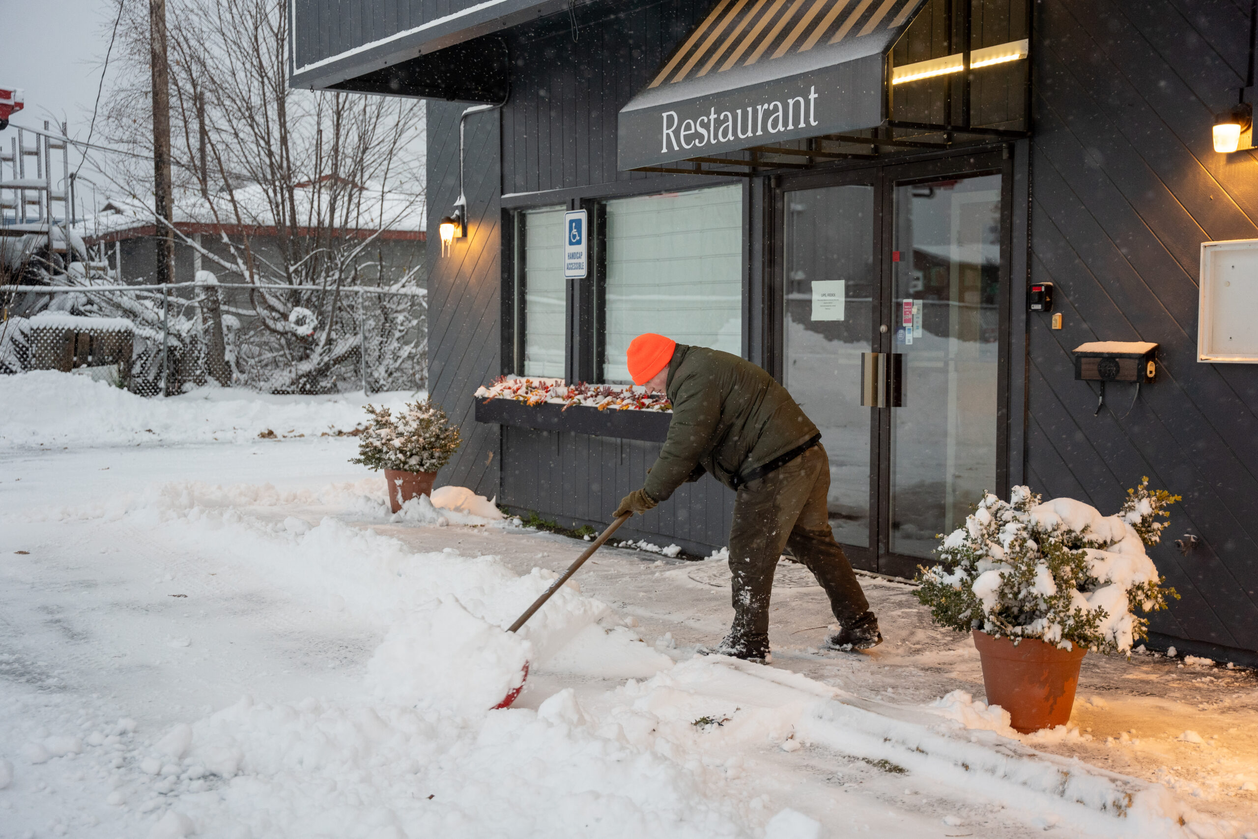 A man cleaning snow with a shovel.