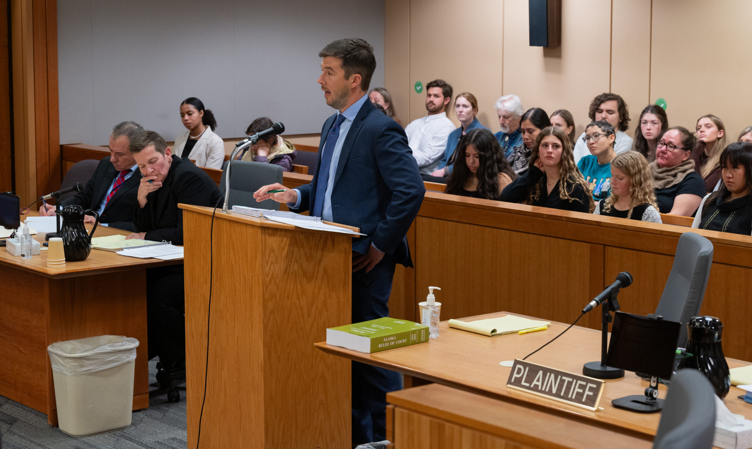 Man speaking in crowded courtroom