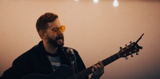 A man plays an acoustic guitar.