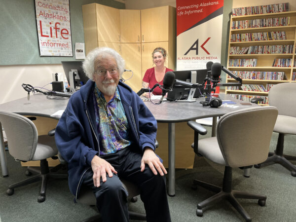 a man and a woman sit in a radio studio. 