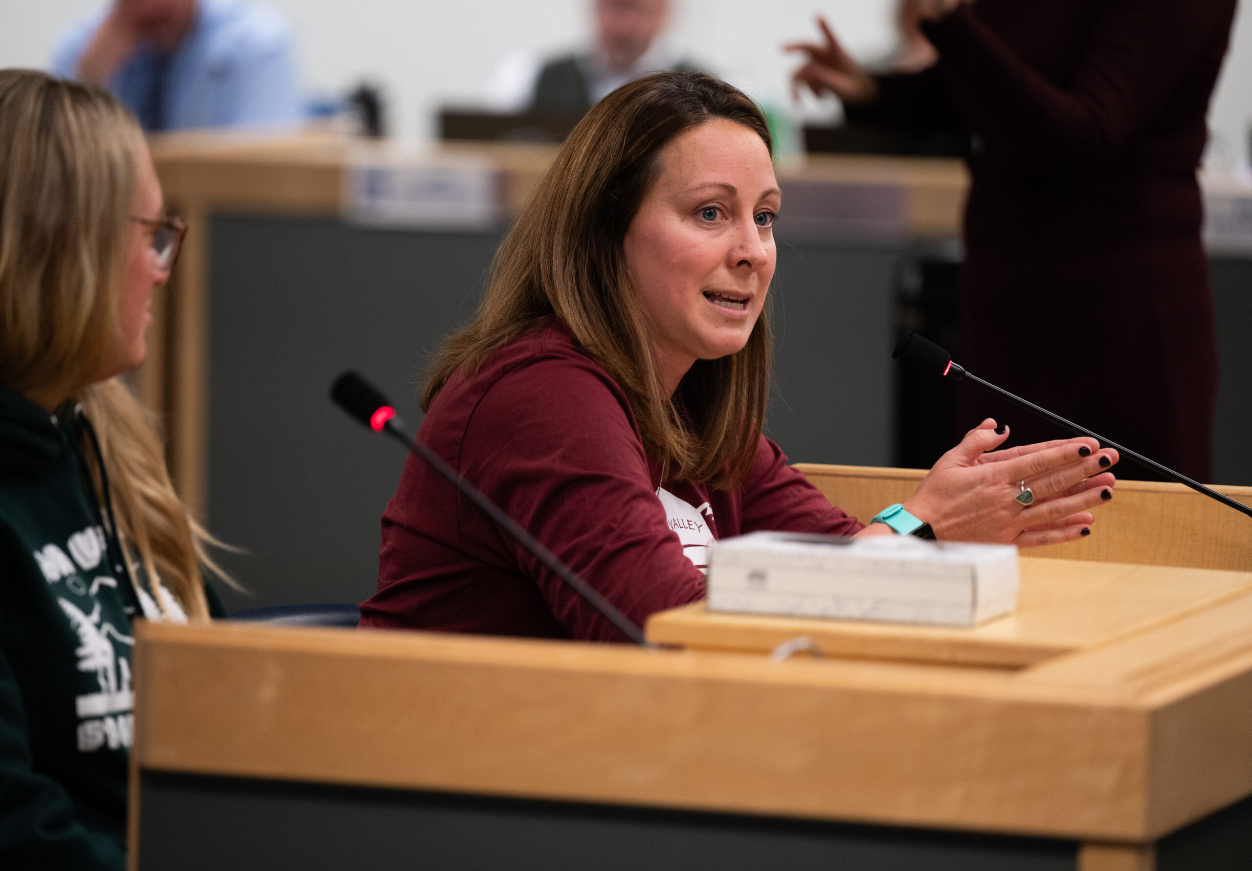 A woman speaks at the podium during a school board meeting in Anchorage.