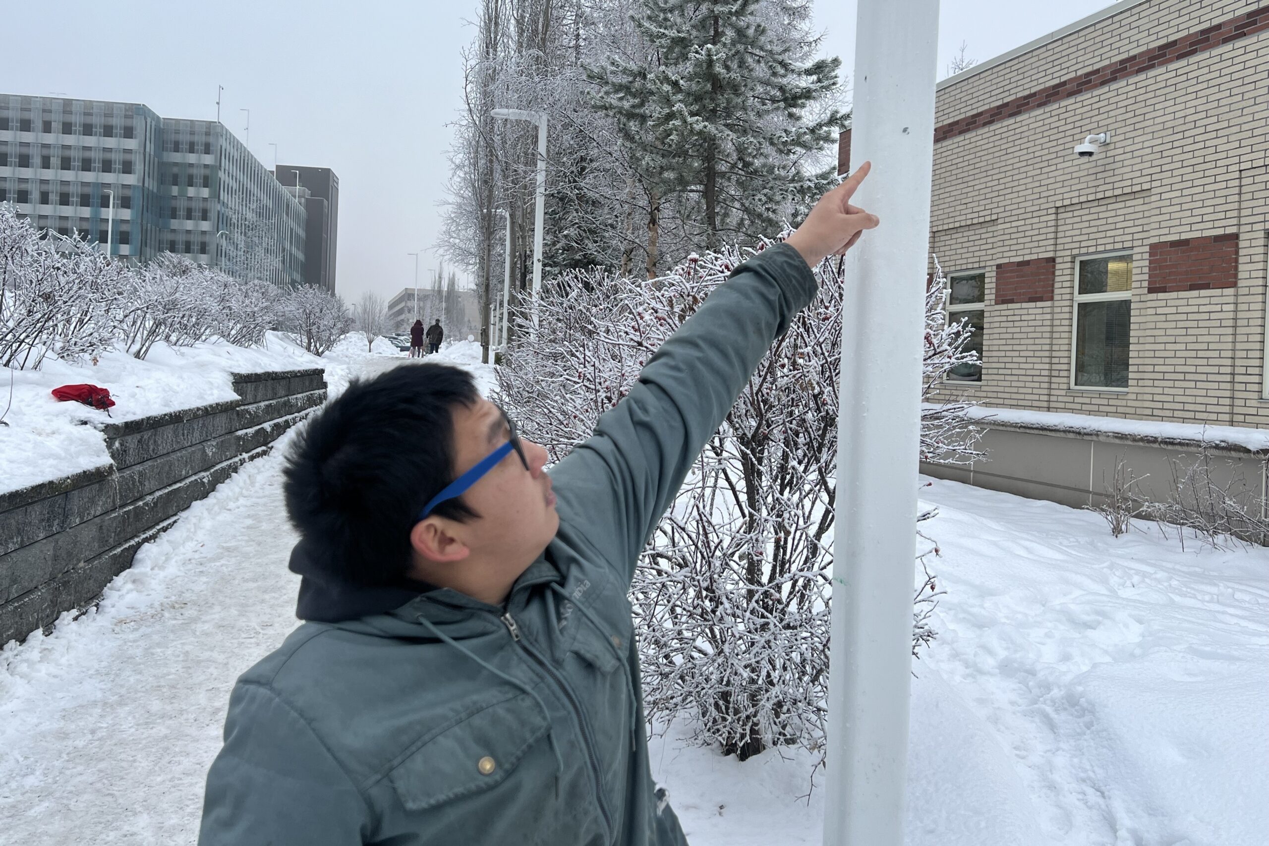 man points to light pole