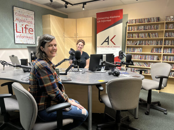 Two women sit in a radio studio. 