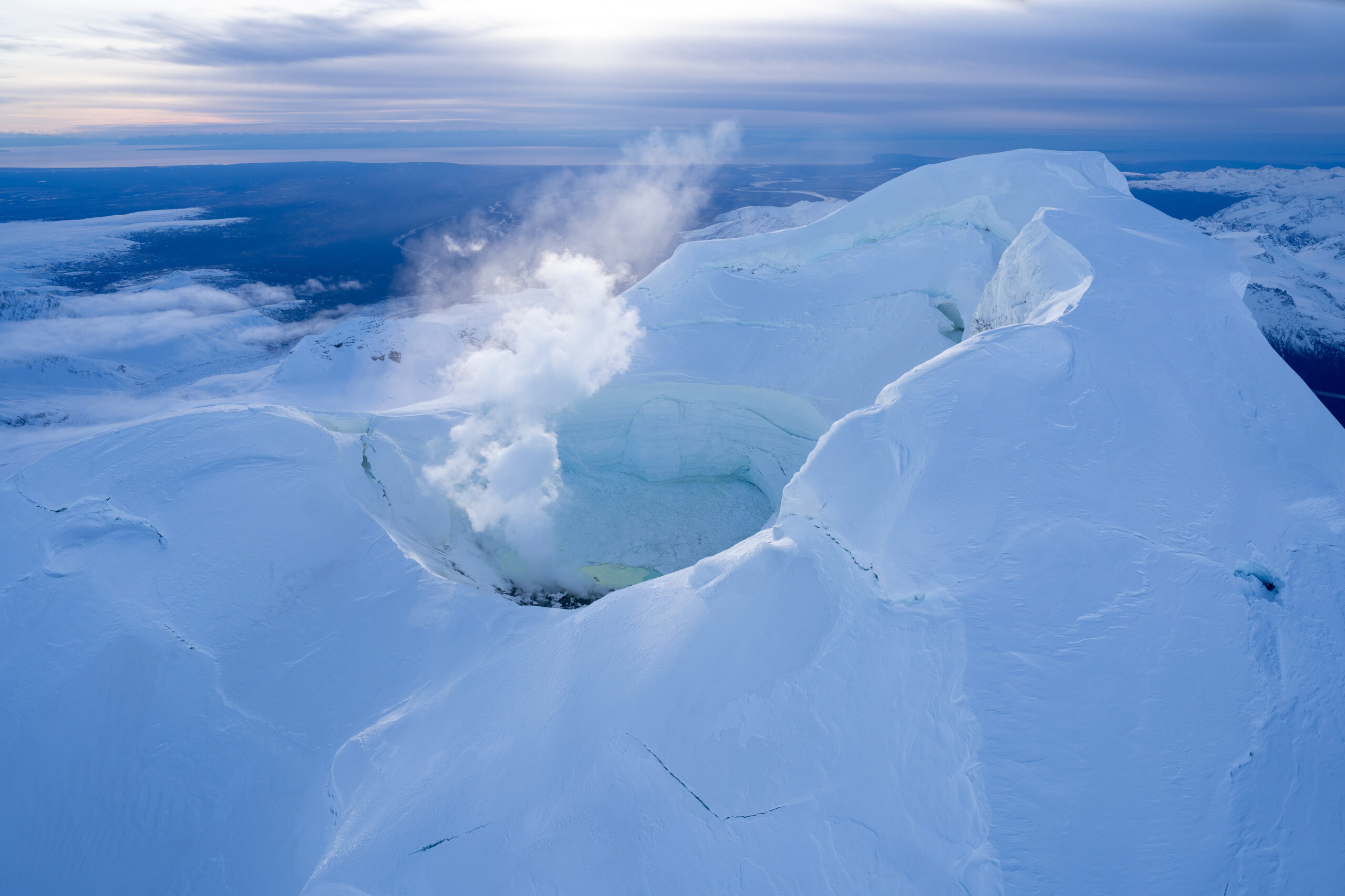 A fuming, snow-covered mountain peak