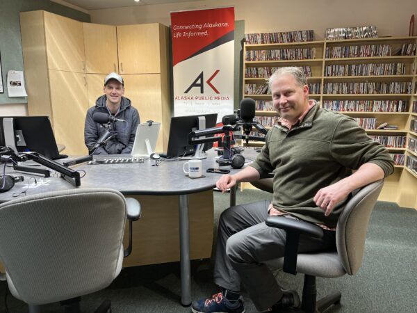 Two men sit in a radio studio.